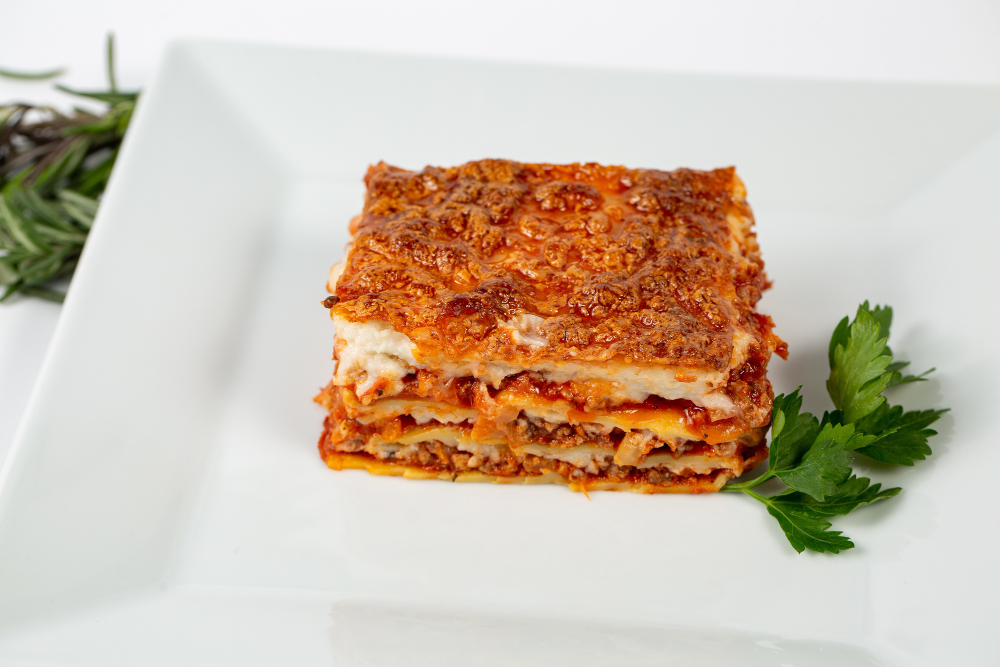 Closeup shot of lasagna on a white plate.